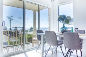 a dining room with a table and chairs and a balcony at Beachfront Getaway Pet-Friendly & Near Boat Ramp - Koala Stay in Encounter Bay