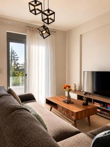a living room with a couch and a flat screen tv at Luxury Family Villa near beach in Lechaio