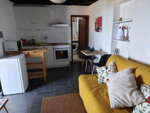 a living room with a yellow couch and a kitchen at El Olivo de Mazo 2 in Mazo
