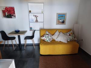 a living room with a yellow couch and a table at El Olivo de Mazo 2 in Mazo