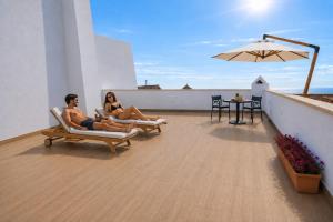 a man and woman sitting on the roof of a house at Antana Guest House in Procida