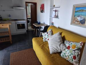 a living room with a yellow couch with pillows at El Olivo de Mazo 2 in Mazo