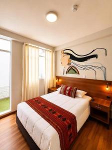 a bedroom with a large bed and a large window at Cusco - Perú "Hotel Boutique Qorikallpa" The true essence of inka culture in Cusco
