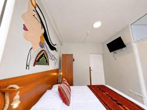 a bedroom with a bed with a painting on the wall at Cusco - Perú "Hotel Boutique Qorikallpa" The true essence of inka culture in Cusco