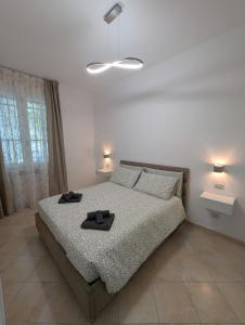 a bedroom with a bed with two black slippers on it at Campesio Apartament in Piacenza