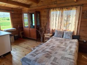 a bedroom with a bed in a wooden cabin at Poilsio nameliai ūkyje Šironija in Ambraziškiai
