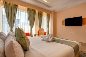 a hotel room with a bed and a television at Hotel Narenn HITEC CITY in Hyderabad