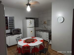 a kitchen with a table and a white refrigerator at Dourados Guest Flat House in Dourados