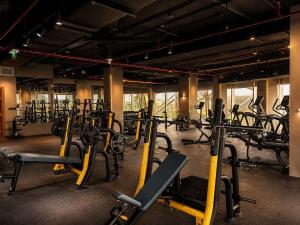 a gym with a lot of treadmills and machines at Century Marina Hotel - Lusail in Lusail
