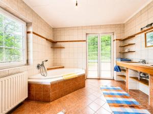 a bathroom with a tub and a sink at ALPINA Appartements Mallnitz in Mallnitz +133 photos