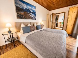 a bedroom with a large bed and a couch at ALPINA Appartements Mallnitz in Mallnitz