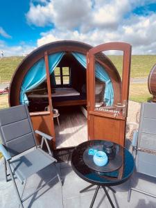 a dome tent with a table and chairs at Claashoff Übernachtungsfass in Hollern-Twielenfleth +12 photos