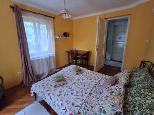 a living room with a bed and a table and a window at Hangvilla Vendégház in Miskolc +4 photos