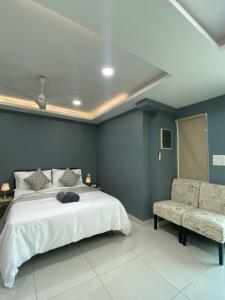 a bedroom with a large bed and a chair at Studio Apartment on a Terrace by Skysuites in Male City +2 photos