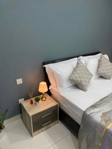 a bedroom with a bed and a nightstand with a lamp at Studio Apartment on a Terrace by Skysuites in Male City