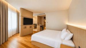 a hotel room with a bed and a flat screen tv at H&H Boutique Hotel in Cukai
