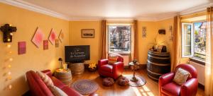 a living room with red chairs and a chalkboard at La Terrasse du Tonnelier - 92m2 - plein centre médiéval - sauna - terrasse 20m2 - garage in Kaysersberg