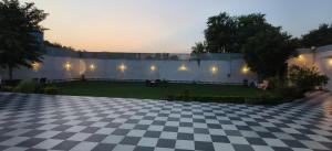 a courtyard with a checkered floor and a wall with lights at hotel celebrations in Jāmb
