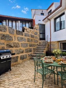 a patio with a table and chairs and a stove at YourHouse O Canton 3 in Lobios