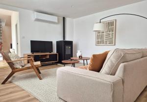 a living room with a couch and a tv at YourHouse O Canton 3 in Lobios