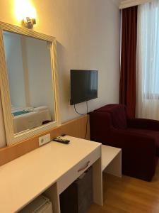 a hotel room with a table and a mirror at Uğur Otel in Kaş