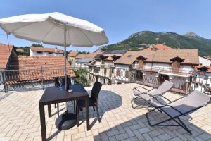 a table and chairs and an umbrella on a patio at Casa Vacanze Andromeda in Agerola