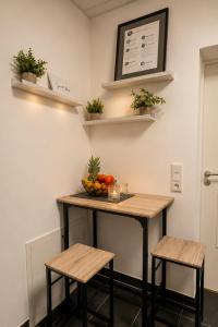 a table with two stools and a bowl of fruit on it at Schängel Chic 27 in Koblenz