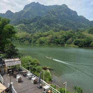 a boat on a river with mountains in the background at Nam Ou View Villa Corner in Nongkhiaw +53 photos