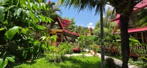 a resort with a palm tree and a building at Mekong Delta Ricefield Lodge in Can Tho