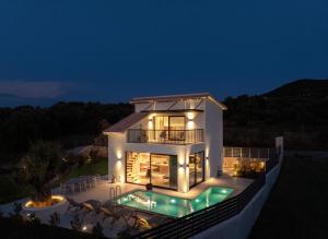 a large house with a swimming pool at night at Avelia Villa Tsoukalades in Tsoukalades +11 photos