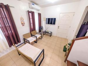 a living room with chairs and a white door at Panglao 4 Bedroom Family and Group House With Pool in Dauis