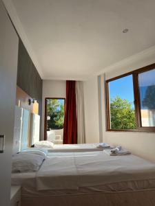 a bedroom with two beds and a large window at Uğur Otel in Kaş +23 photos