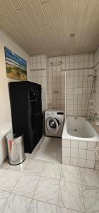 ein Badezimmer mit Badewanne und Waschmaschine in der Unterkunft Miniapartement in Netzschkau