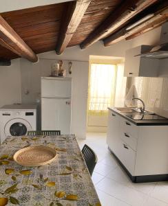 a kitchen with a table and a counter top at Casetta in piazza in Palazzo Adriano