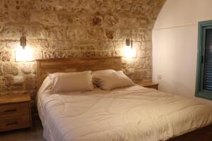 a bedroom with a white bed with two pillows at Ayham dream house in Acre