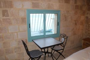 a table and chairs in a room with a window at Ayham dream house in Acre