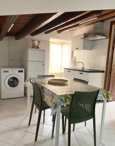 a kitchen with a table and chairs and a washing machine at Casetta in piazza in Palazzo Adriano