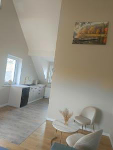 a kitchen with a table and two chairs and a sink at Apartament Oliwia in Grywałd
