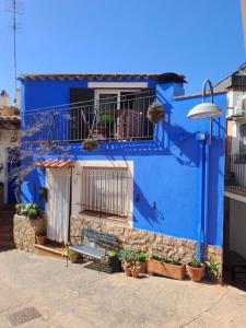a blue building with a bench in front of it at Ca la Pepa in Begur