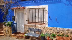 a blue building with a bench in front of it at Ca la Pepa in Begur
