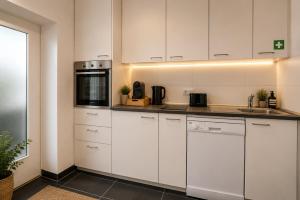 a kitchen with white cabinets and a sink at Schängel Chic 27 in Koblenz