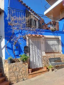 a blue building with a door and a balcony at Ca la Pepa in Begur
