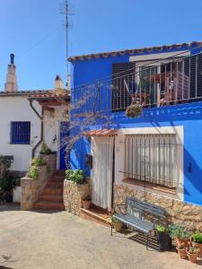 a blue building with a bench in front of it at Ca la Pepa in Begur