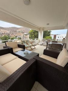 a balcony with wicker furniture and a view of the city at Radisson blu résidence alhcoeima in Al Hoceïma