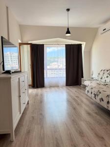 a bedroom with a bed and a large window at Видовые 2-комнатное апартаменты в комплексе Varna South Bay in Asparukhovo