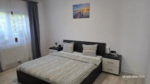 a bedroom with a bed with a striped comforter at Casa Magurele in Măgurele