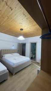 a bedroom with a large bed and a wooden ceiling at Vila Lukas in Ksamil +13 photos