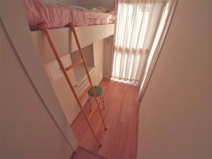 Palette Takashimadaira guest house في طوكيو: غرفة صغيرة مع سرير بطابقين ودرج