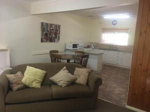 ein Wohnzimmer mit einem Sofa und einer Küche in der Unterkunft Ovensview On Riverside in Bright
