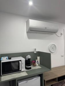 eine Mikrowelle auf einer Theke mit einer Uhr an der Wand in der Unterkunft Casa Noa in Marginea + 8 Fotos